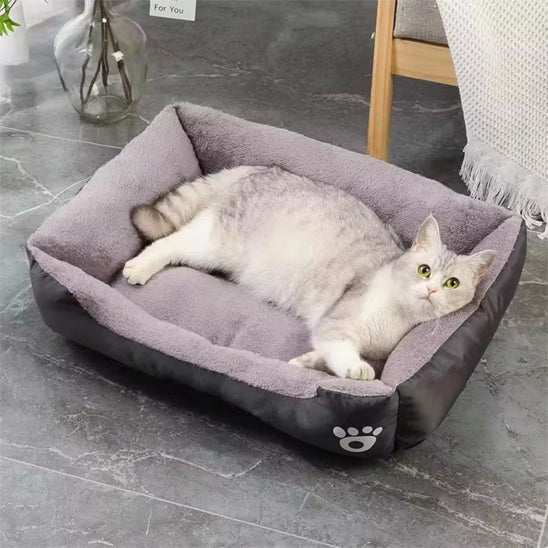 Lit pour chat noir avec intérieur gris, parfait pour un sommeil profond et relaxant.