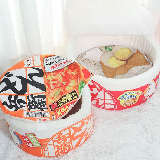 Panier pour chat en forme de bol de ramen avec garnitures moelleuses et couvercle ouvert.