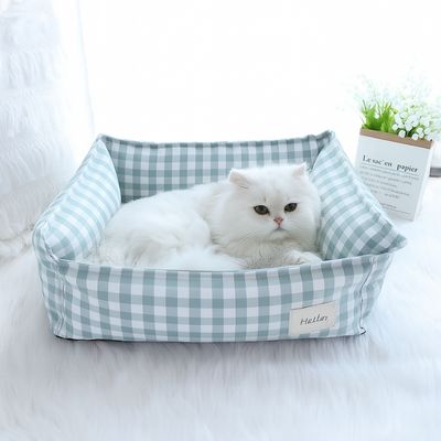 Lit pour chat Purrlit vert clair avec coussin à motif carreaux type plaid.