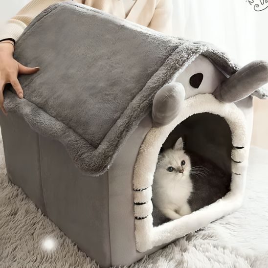 Chat blanc installé dans une grande niche FéliNiche sans fenêtre, toit ondulé et intérieur moelleux.