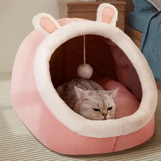 Niche chat douillette rose avec oreilles de lapin, cocon moelleux et sécurisant pour sieste féline.