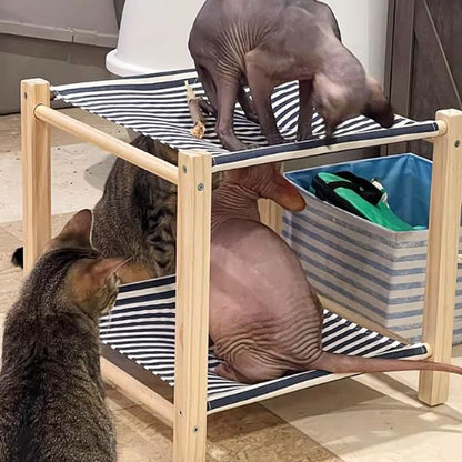 Chats Sphynx et tigré jouant sur un hamac pour chat à deux niveaux, structure bois et tissu rayé – stable, solide, lavable.