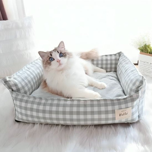  Lit pour chat vert clair avec un chat à poils longs, blanc et beige, aux yeux bleus, allongé à l’intérieur.